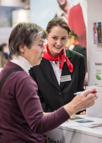 Valentina Ivic tells visitors about the trade fair competition during the nursing care fair in Hanover.