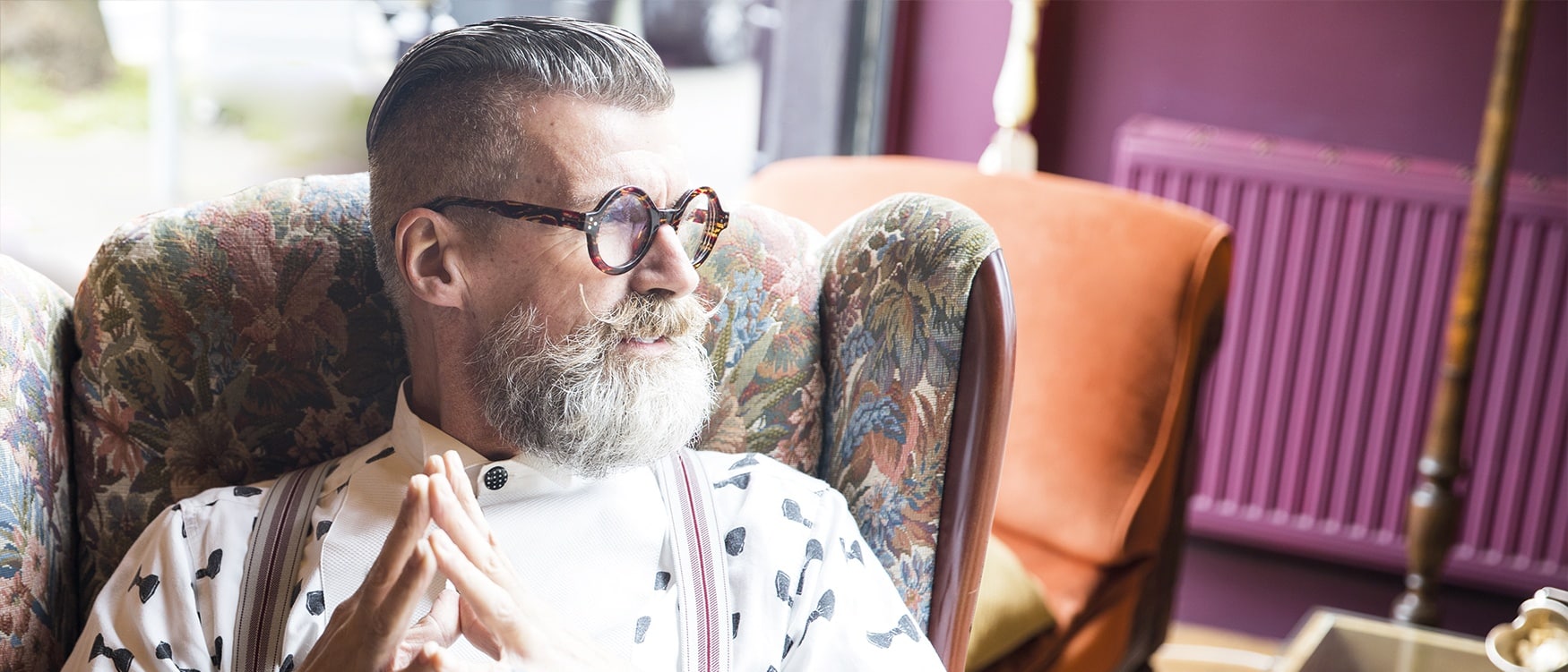 Quirky vintage senior man looking out through tea rooms window